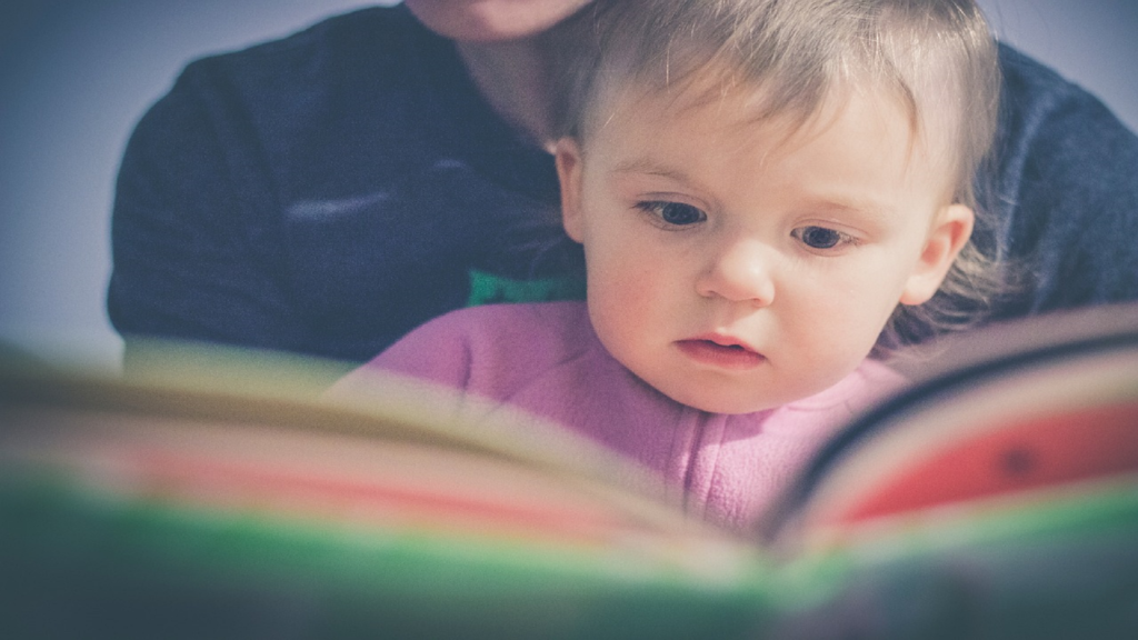 Imagem de um bebê lendo para artigo livros para bebês